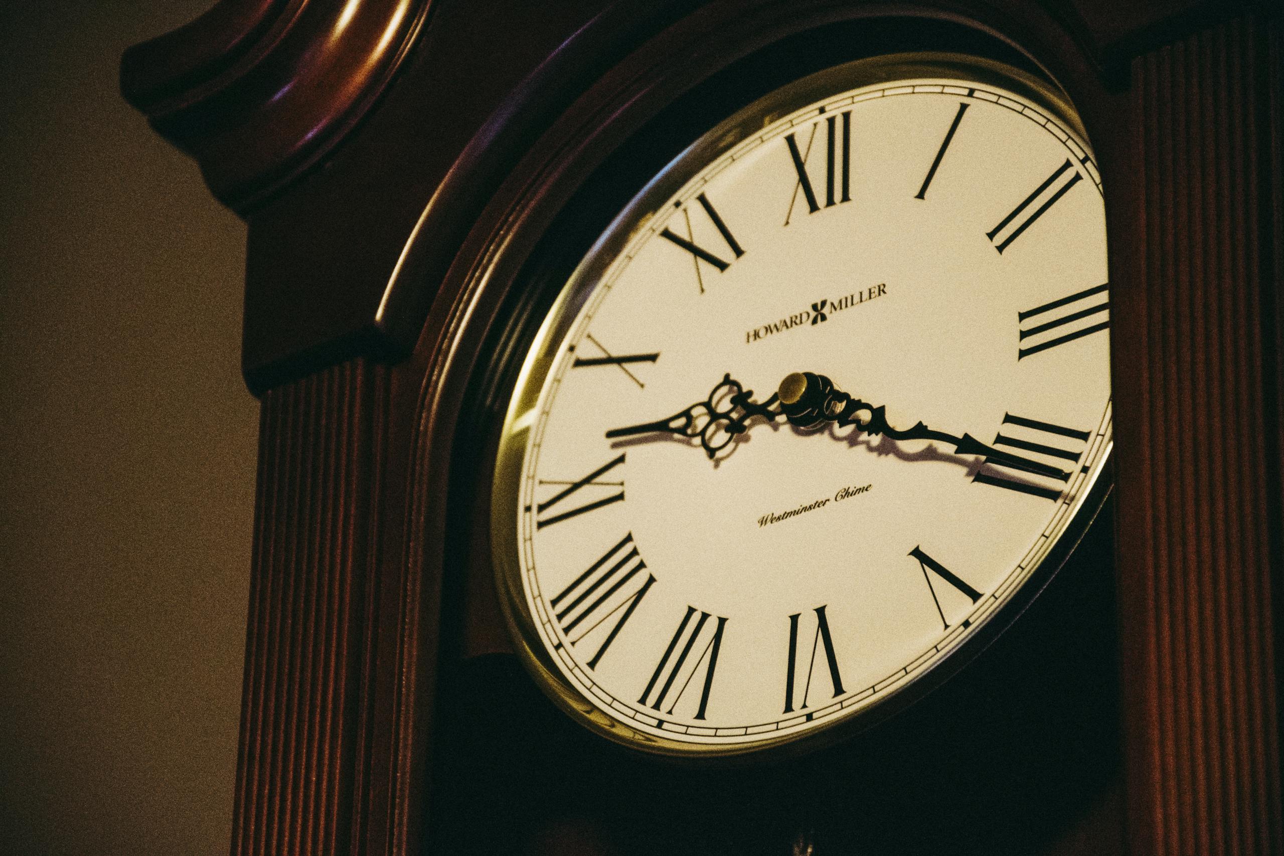 Close-up of an ornate vintage grandfather clock with Roman numerals.